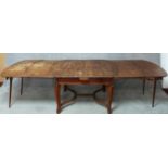 A vintage French oak extending dining table fitted with four extra leaves and integral end supports.