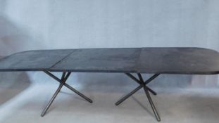 WITHDRAWN - A contemporary twin pedestal ebonised dining table on metal framed tripod supports with
