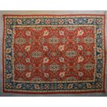 A Kilim with repeating scrolling floral design surrounded by an azure stylised flowerhead border.