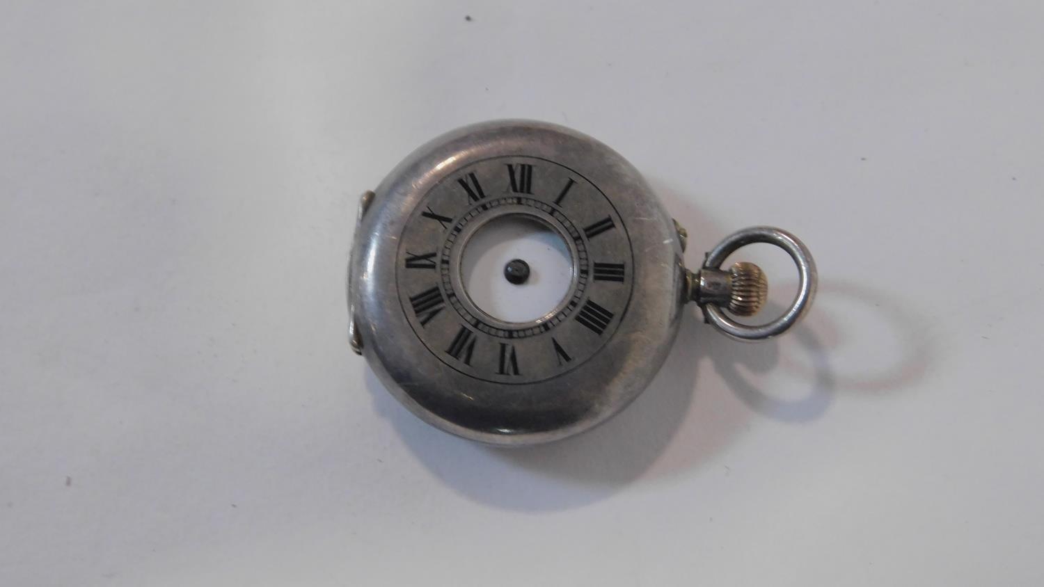 An antique small silver half hunter fob watch. Hallmarked with swiss hallmarks, 935. White enamel