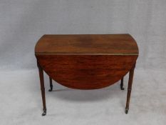 A Regency well figured mahogany Pembroke table on ring turned tapering supports terminating in brass