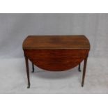 A Regency well figured mahogany Pembroke table on ring turned tapering supports terminating in brass