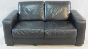 A contemporary two seater sofa in black leather by Natuzzi. H.80 W.160 D.90cm