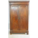 An antique French flame mahogany linen wardrobe with panel doors enclosing shelves on block feet.