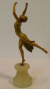 An Art Deco gilded and painted spelter of a female dancer in elegant streched pose, mounted on an
