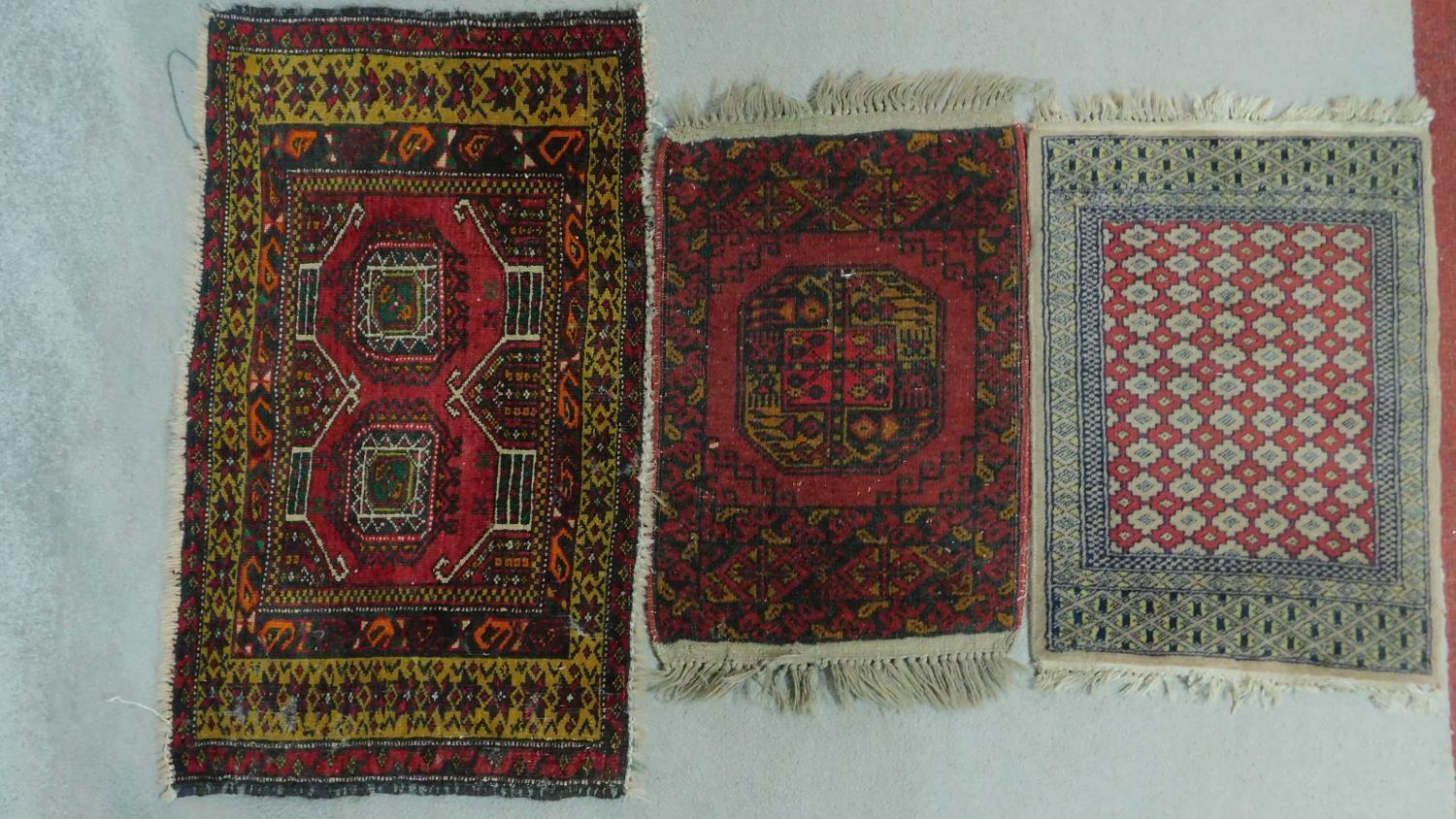 A Kazak rug with central lozenge medallions on a rouge field within floral multi borders and two