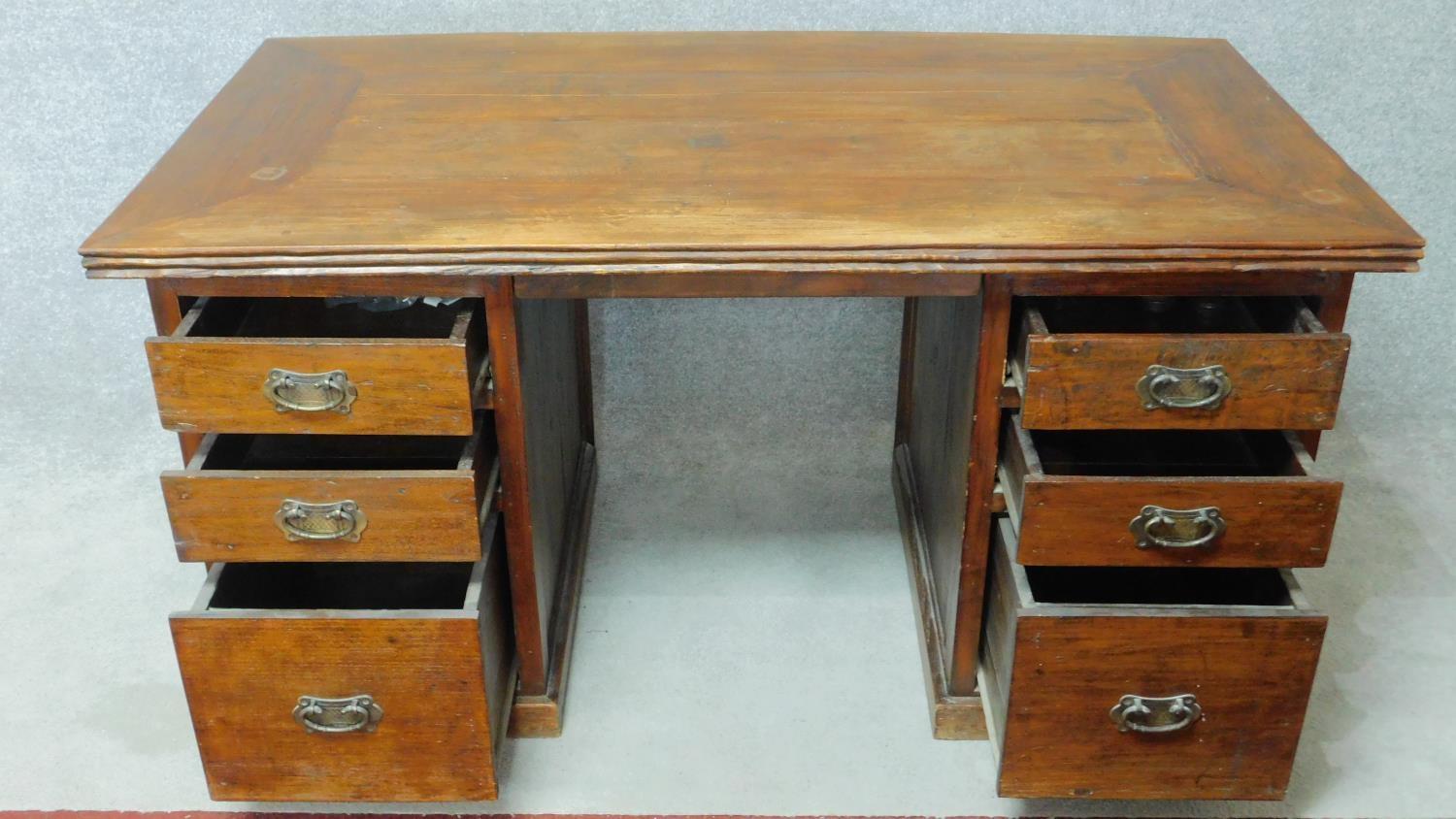 An Eastern teak pedestal desk with planked top and central kneehole section flanked by three - Image 2 of 3