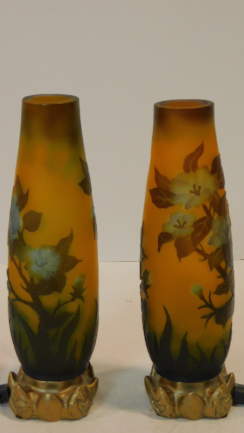 A pair of Galle style cameo glass lamps with floral design on gilded metal floral form bases. H.23cm
