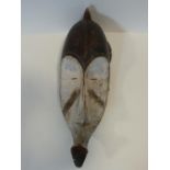 A carved and painted African DRC Gabon Fang Ngil wooden mask. H.56cm