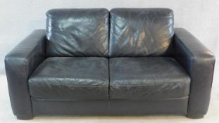 A contemporary two seater sofa in black leather by Natuzzi. H.80 W.160 D.90cm