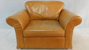 A contemporary armchair in light tan leather upholstery. H.90 W.130 D.100cm