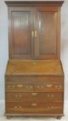 A Georgian country oak bureau bookcase with upper section fitted with fielded panel doors