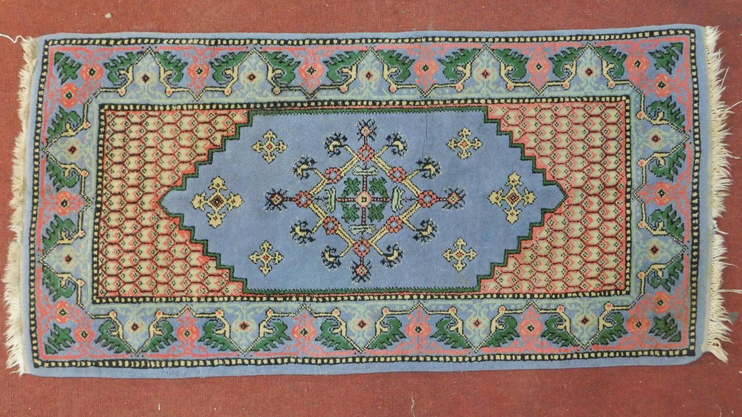 A Samarkand rug with central lozenge medallion on pale blue ground within a naturalistic floral