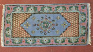 A Samarkand rug with central lozenge medallion on pale blue ground within a naturalistic floral