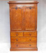 A mid 19th century well figured mahogany linen press with fielded panel doors enclosing linen slides