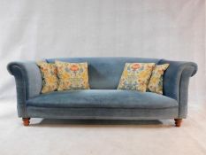 A contemporary Victorian style tub shaped two seater sofa upholstered in pale blue velour on