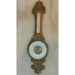 A late 19th century carved oak aneroid barometer with mercury thermometer. 90x25cm