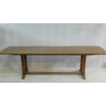 An oak refectory style dining table on stretchered chamfered square section supports on platform