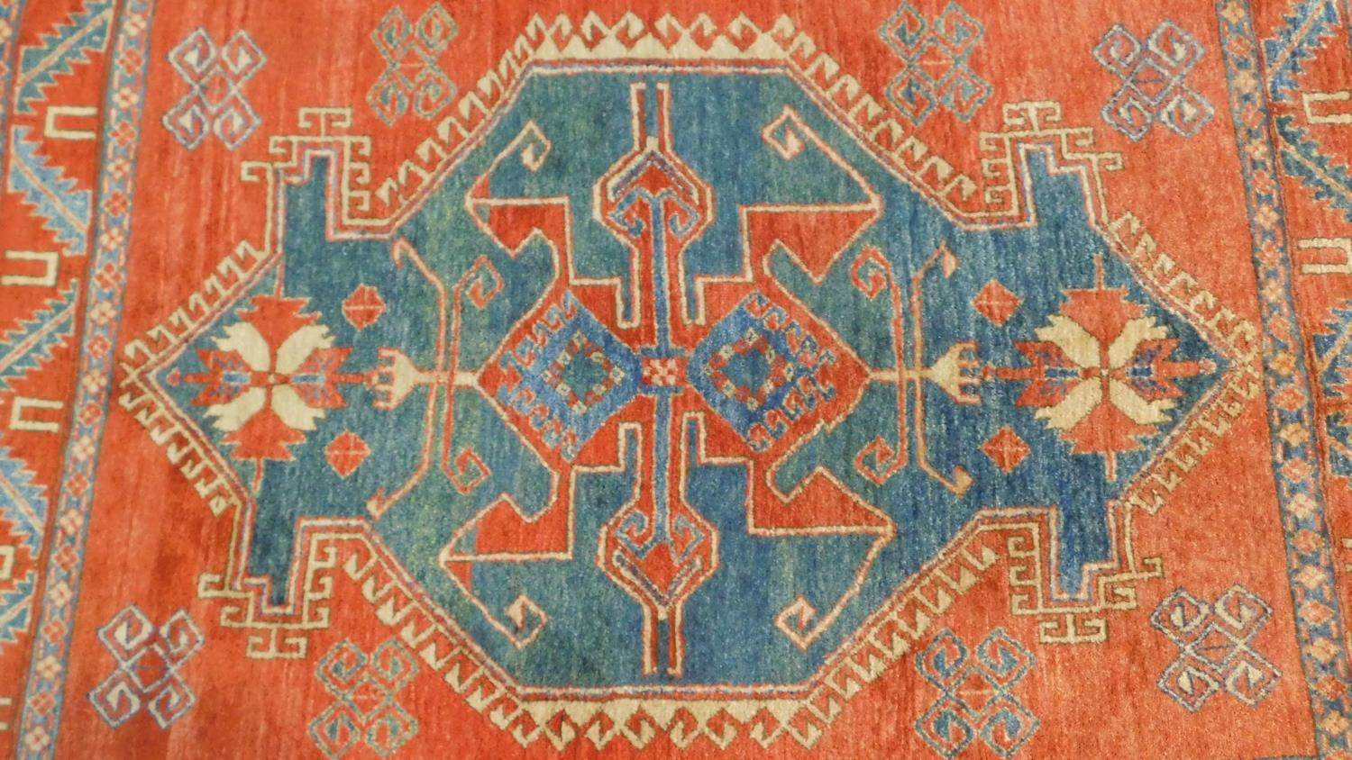 A Kazak rug with central medallion on azure ground within a pale burgundy field and stylised - Image 2 of 4