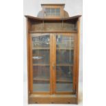 A late 19th century oak Art Nouveau bookcase in the Glasgow School style with leaded glazed