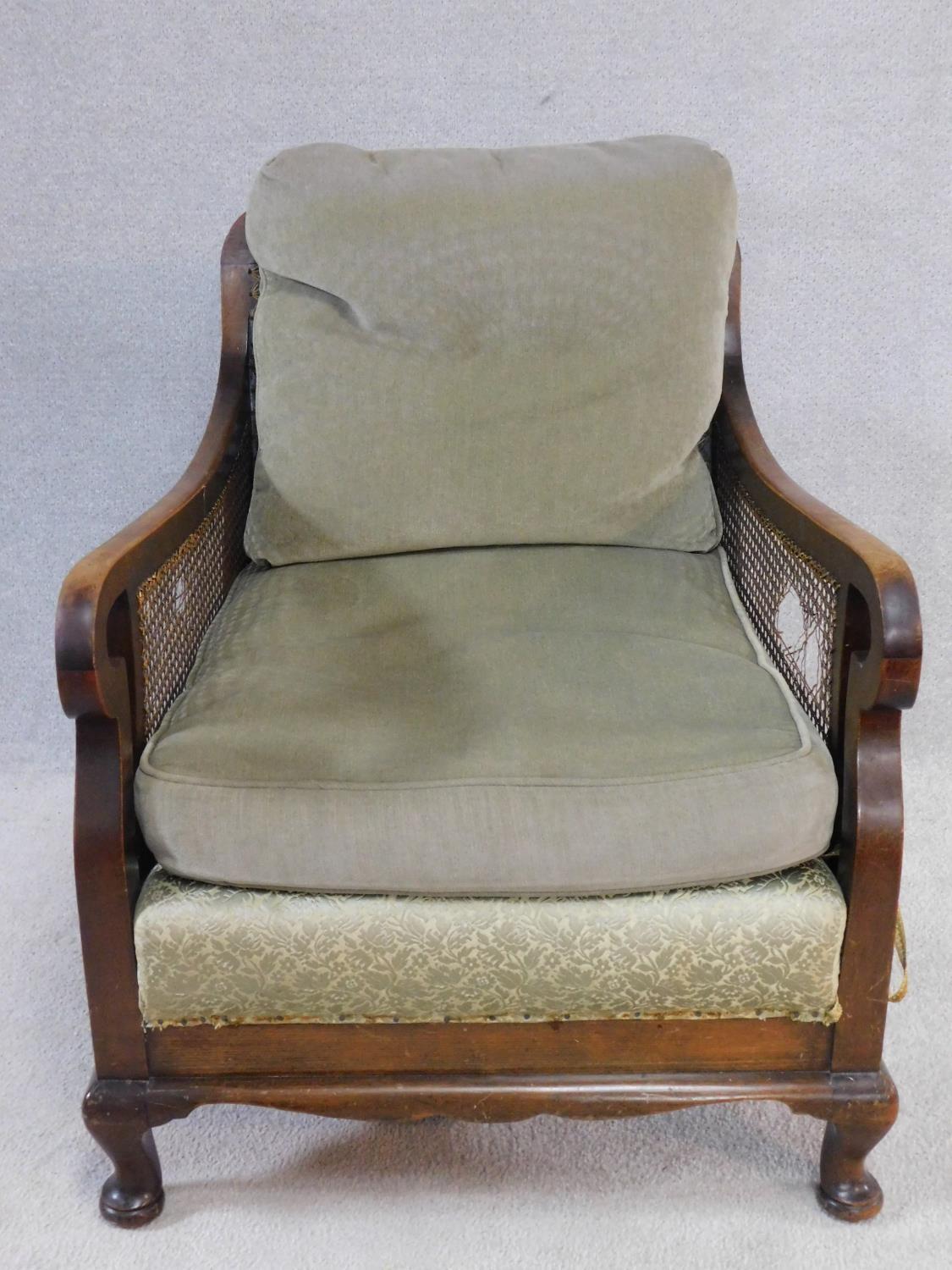 A mid century mahogany framed bergere armchair with squab cushions to seat and back. H.79 W.74 D.