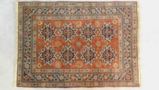 A Shirvan rug with repeating geometric medallions on a burgundy field within floral midnight multi