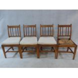 A set of four antique country elm dining chairs with carved rail backs and rush drop in seats. Three