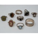 A collection of silver and gemstone rings. Including a silver band with geometric design and set