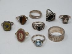 A collection of silver and gemstone rings. Including a silver band with geometric design and set