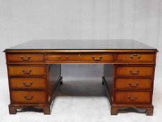 A Georgian style mahogany partner's desk with glass plate on tooled leather inset above an