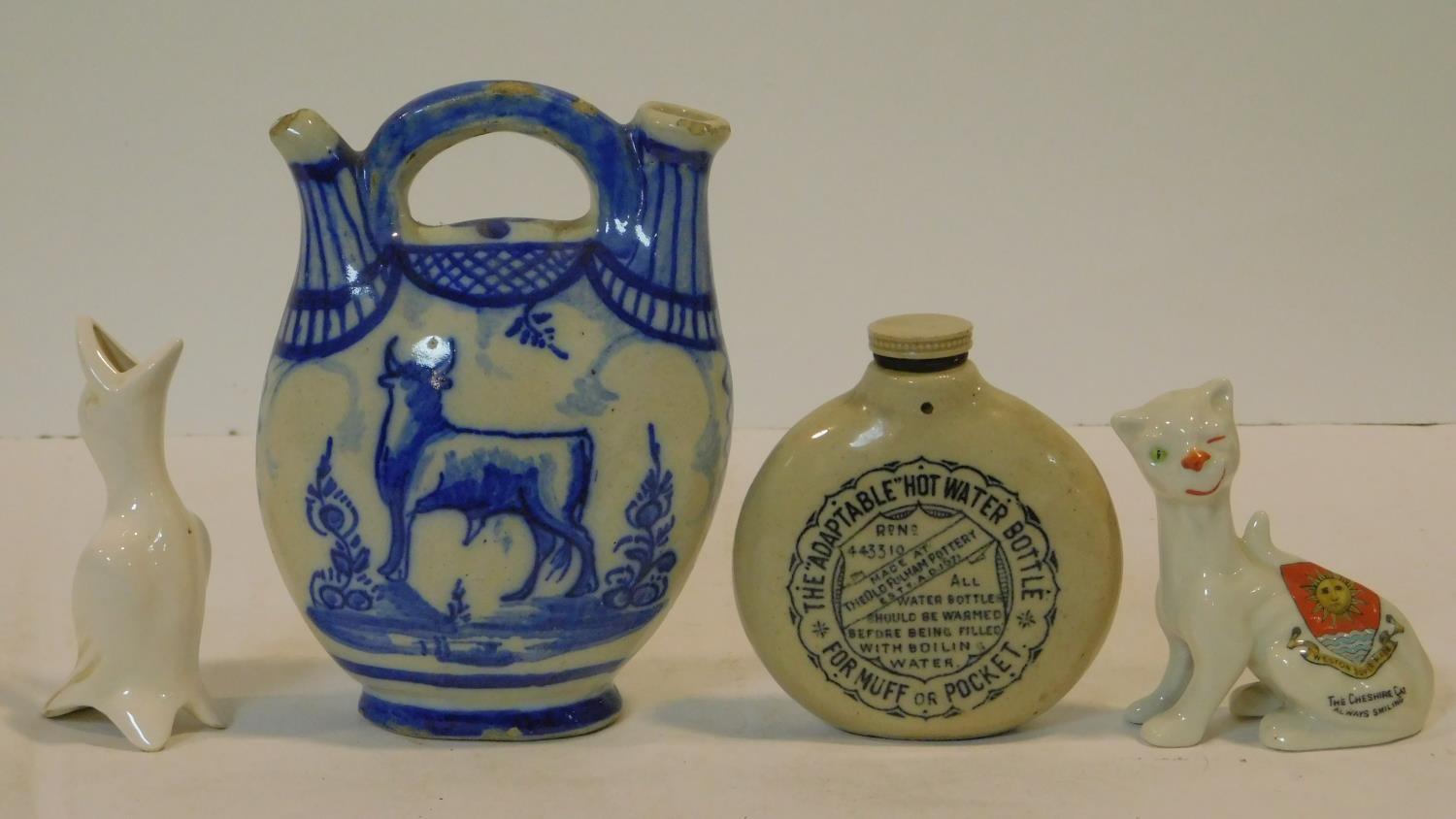 A collection of antique ceramic items. Including a blue and white Delft twin spout jug with cow