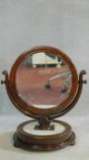 A 19th century swing mirror in mahogany frame on circular marble base with its original glass. H.