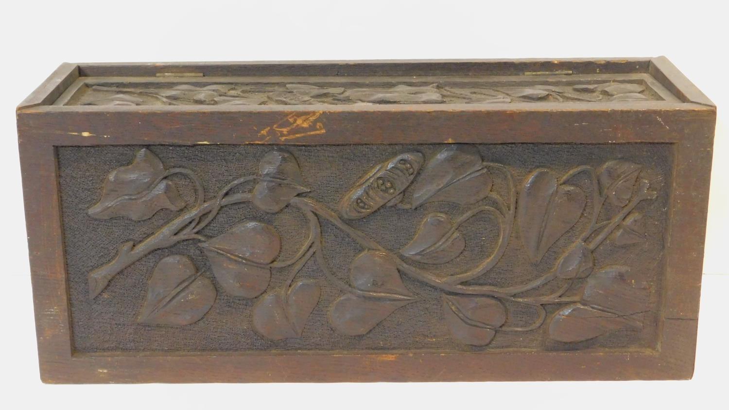A late 19th century oak stationery casket with Arts and Crafts style floral carved panels. H.22 W.50