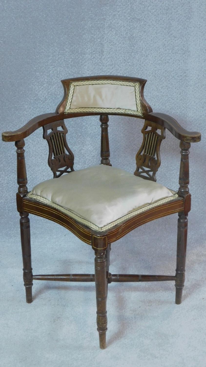 An Edwardian mahogany corner chair with lyre carved splats on turned stretchered supports. H.72cm