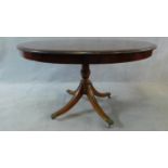 A 19th century mahogany tilt top dining table on quadruped swept supports on brass lion's paw