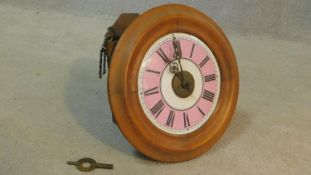 An early 20th century oak cased postman's alarm clock with coloured enamel dial, Roman numerals