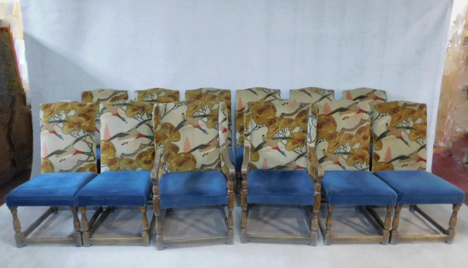 A set of twelve Jacobean style oak dining chairs in Arts and Crafts flying duck motif upholstery