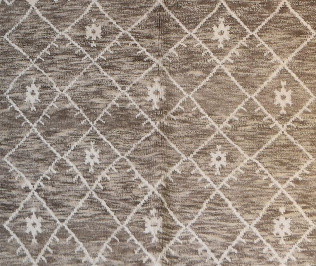 A Moroccan rug with repeating geometric, flowerhead and pendant design on a taupe ground. L. - Image 2 of 3