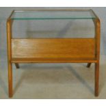 A mid century vintage teak magazine table with plate glass top and open book shelf. H.53 W.65 D.51cm