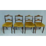 A set of four late Victorian beech dining chairs with profusely floral inlaid back rails on tapering