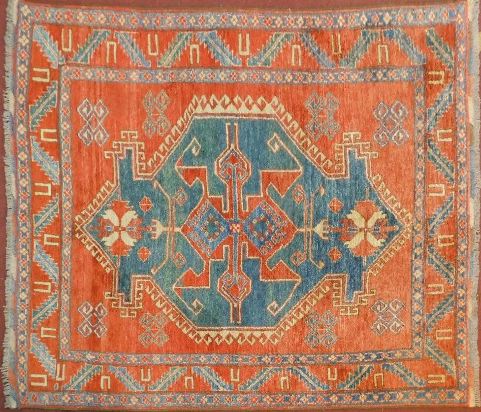 A Kazak rug with central medallion on azure ground within a pale burgundy field and stylised