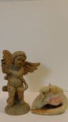 A carved wood cherub candle holder along with an alabaster light in the form of a putti climbing