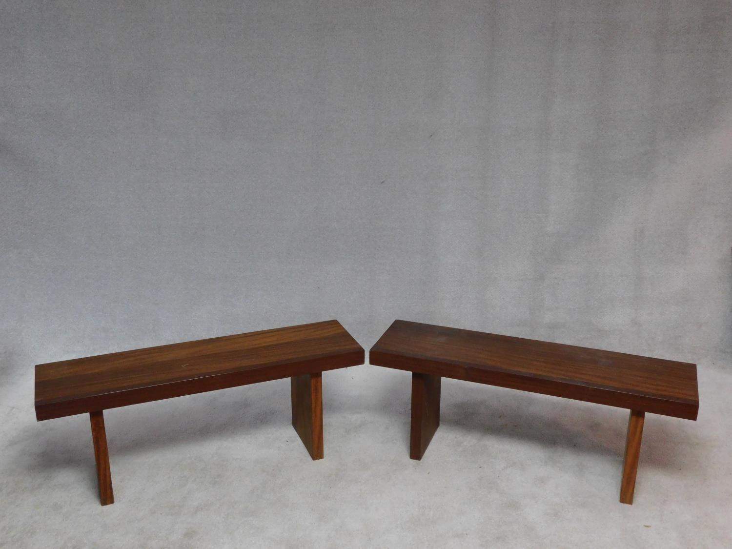 A pair of African hardwood benches with planked tops on block trestle supports. H.47 W.104 D.42cm