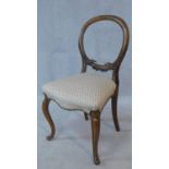 A Victorian walnut balloon back dining chair with well carved back above newly upholstered stuffover