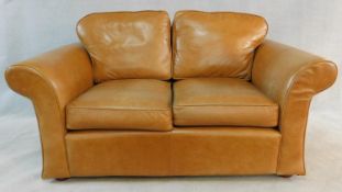 A contemporary two seater sofa in light tan leather upholstery. H.90 W.170 D.98cm