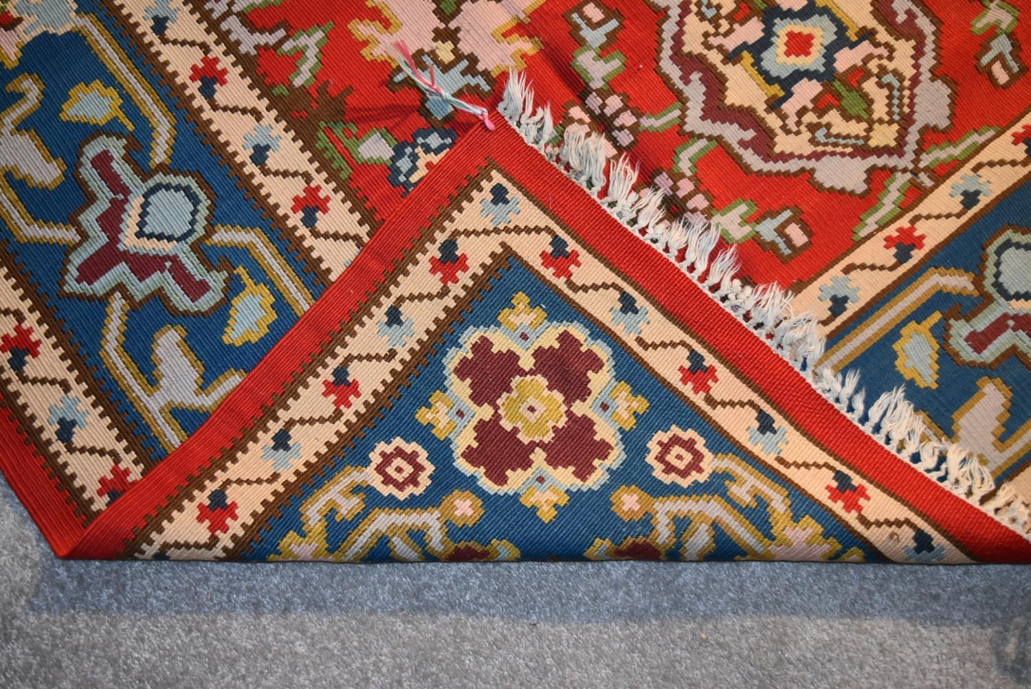 A Kilim with repeating scrolling floral design surrounded by an azure stylised flowerhead border. - Image 4 of 4