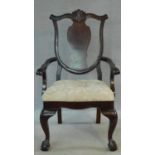 An early 20th century mahogany Georgian style open armchair with floral damask drop in seat on