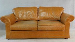 A contemporary two seater sofa bed in light tan leather upholstery. H.70 W.205 D.100cm