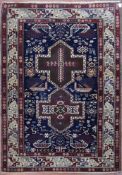 A fine Kazak style rug with double central medallions on indigo field with stylised animal and