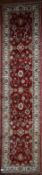 A Ziegler style Runner with all over scrolling foliate motifs on a burgundy field within floral